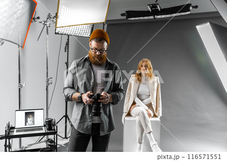 Professional photo shoot setup with photographer and model for artistic or commercial needs Professional photo shoot setup with photographer and model for artistic or commercial needs 116571551