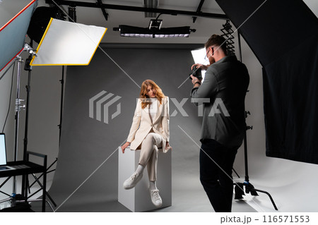 Studio photoshoot with model and photographer for artistic, commercial, or editorial purposes Studio photoshoot with model and photographer for artistic, commercial, or editorial purposes 116571553