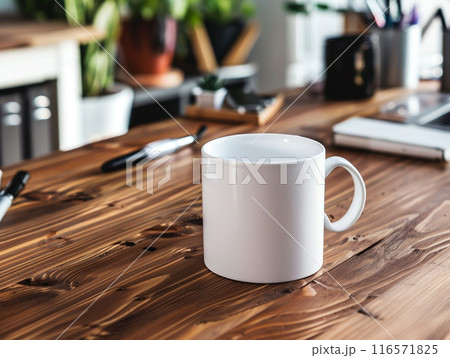 A white mug sitting on a vintage aged rosewood desk with various modern office supplies organized around it.  A white mug sitting on a vintage aged rosewood desk with various modern office supplies organized around it.  116571825