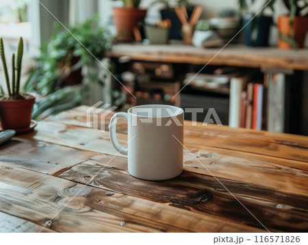A white mug sitting on a vintage aged rosewood desk with various modern office supplies organized around it.  116571826
