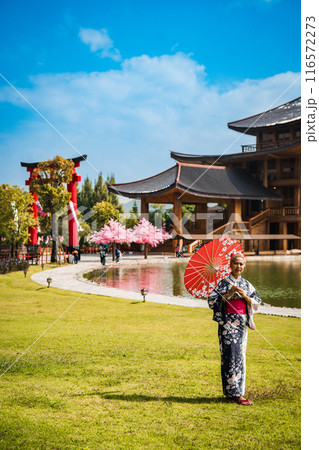 Asian girl in kimono and umbrella in Japanese theme park Hinoki Land in Chai Prakan District, Chiang Asian girl in kimono and umbrella in Japanese theme park Hinoki Land in Chai Prakan District, Chiang 116572273