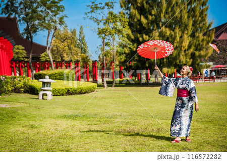 Asian girl in kimono and umbrella in Japanese theme park Hinoki Land in Chai Prakan District, Chiang 116572282