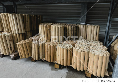 Stacks of Wooden Fence Posts in Store or Warehouse Storage for Outdoor Landscaping and Fencing. 116572573