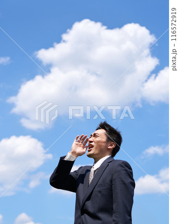 青空のもと大声で叫ぶ男性 116572919