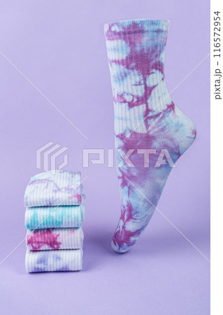 Tie dye colorful socks on purple background. volumetric sock and stack of different Tie dye socks. 116572954