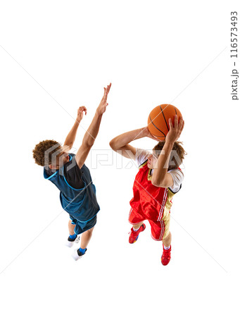 Two dedicated basketball players, with one in blue jersey blocking path of other in red jersey, who focused on scoring against white studio background. Aerial view. 116573493