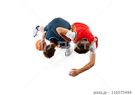 High-energy moment in basketball game as two players vie for control of ball against white studio background. Dribbling. Aerial view. 116573494