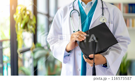 Doctor holding graduation gap hat, education medicine. 116573587