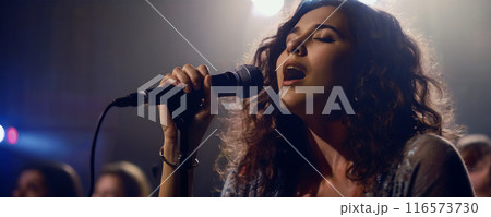 Young Woman Singing on Stage with Microphone 116573730