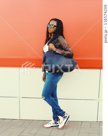 Fashionable young African woman with handbag in casual, stylish black girl posing in the city Fashionable young African woman with handbag in casual, stylish black girl posing in the city 116574209