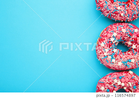 Donuts with icing on pastel blue background. Sweet donuts. Donuts with icing on pastel blue background. Sweet donuts. 116574897
