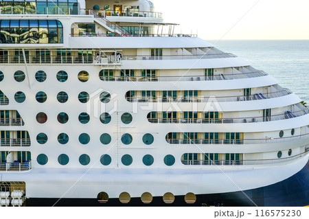 Large cruise ship side view fragment with round portholes rows and cabins balconies with railing 116575230