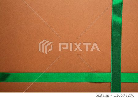 Green ribbon on brown background with clipping path. 116575276
