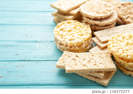 Different types of crispbread on blue wooden background. 116575277