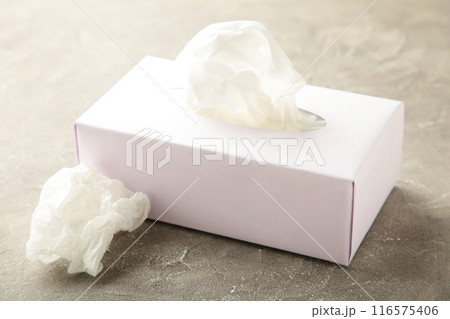 Box with paper tissues and used crumpled napkins on grey background 116575406