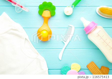 Baby milk with toys and clothes on grey background 116575413