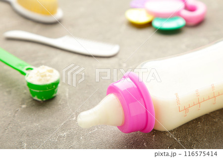 Baby milk with toys on grey background 116575414