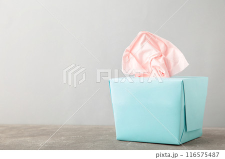 Blue box with paper tissues on grey background with copy space 116575487