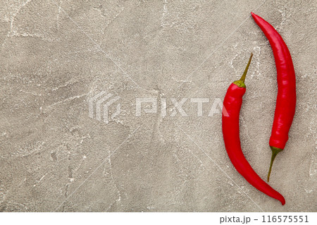 Red hot chili peppers on grey background Red hot chili peppers on grey background 116575551