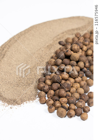 Ground black pepper and peppercorns close-up. Ground black pepper and peppercorns close-up. 116575946