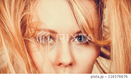 Blonde woman holding her long tangled hair 116576676