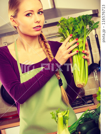 Woman in kitchen with green vegetables 116576713