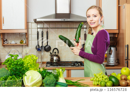 Woman housewife in kitchen with green vegetables 116576728