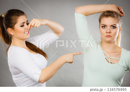 Woman having wet armpit her friend smelling stink 116576995