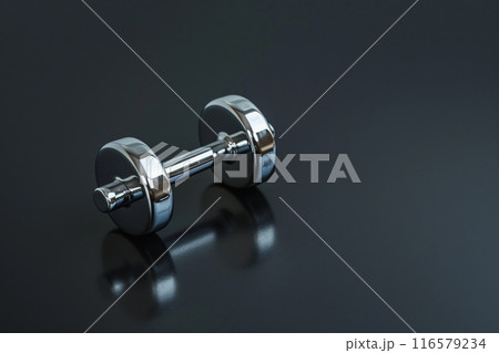 反射する表面に置かれているメタリックなダンベルとコピースペース 116579234