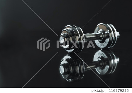 反射する表面に置かれているメタリックなダンベルとコピースペース 反射する表面に置かれているメタリックなダンベルとコピースペース 116579236