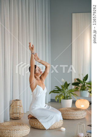 Girl in white dress does aesthetic gymnastics in gym. Girl doing yoga in the gym Girl in white dress does aesthetic gymnastics in gym. Girl doing yoga in the gym 116579262