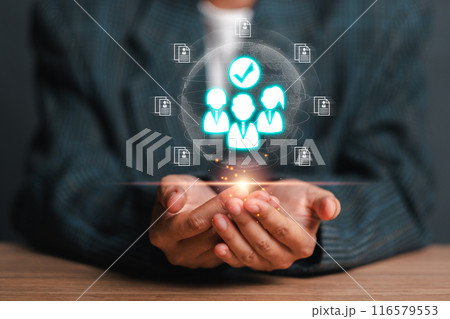 Business professional holding holographic icons representing human resources, teamwork, and digital innovation in a modern business environment. Business professional holding holographic icons representing human resources, teamwork, and digital innovation in a modern business environment. 116579553