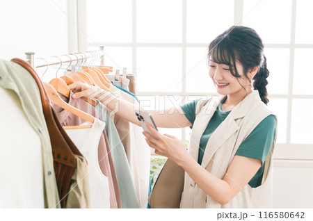アパレルショップで洋服を買い物・ショッピングする女性 アパレルショップで洋服を買い物・ショッピングする女性 116580642