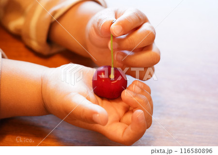 さくらんぼを持つ小さな子供の手 116580896