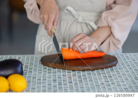 包丁で人参を切る女性の手元 116580997