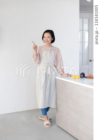 キッチンで指差しをする女性 116581005