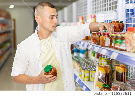 Man shopping at grocery store - choosing tasty Chinese mustard Man shopping at grocery store - choosing tasty Chinese mustard 116582631