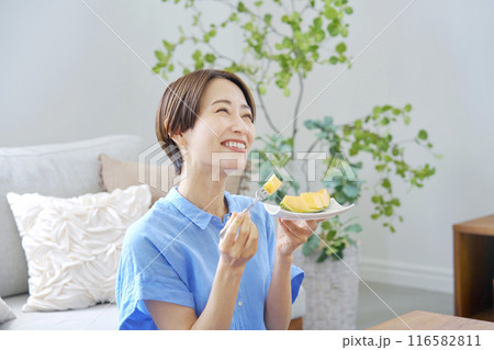 自宅でメロンを食べる女性 116582811