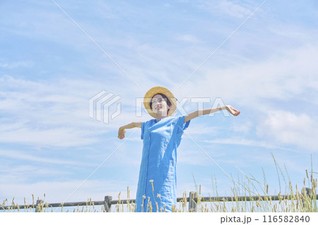 屋外で伸びをする女性 116582840