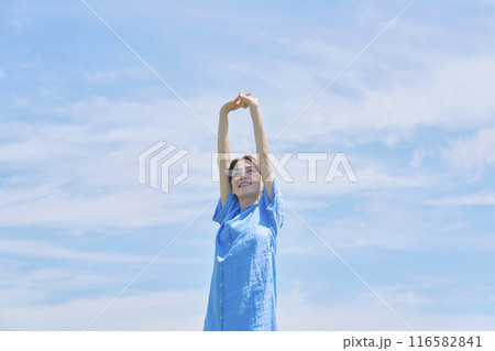 屋外で伸びをする女性 116582841