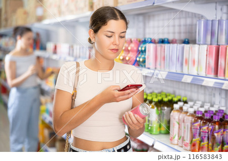Woman looking for soda from photo on internet Woman looking for soda from photo on internet 116583843