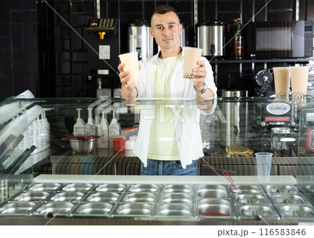 Happy man with two glasses of bubble tea in the grocery department of supermarket Happy man with two glasses of bubble tea in the grocery department of supermarket 116583846