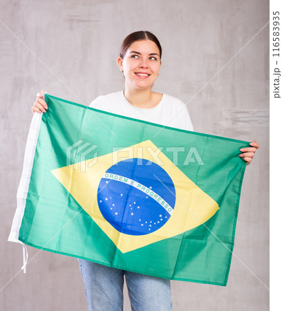 Attractive female football fan holding Brazilian flag 116583935