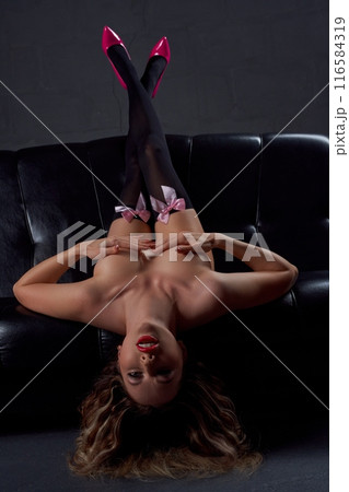 Alluring woman touching naked boobs lying on leather sofa Alluring woman touching naked boobs lying on leather sofa 116584319