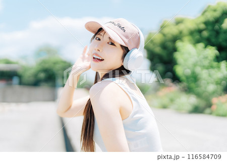 屋外で音楽を聴く若い女の子 116584709