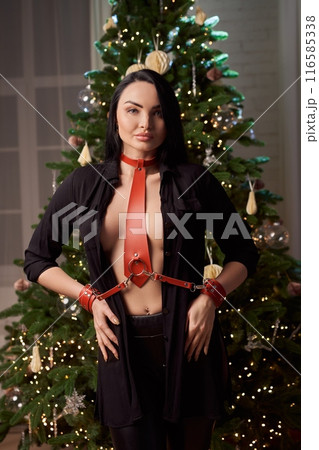 Seductive woman in bdsm outfit with handcuffs near Christmas tree Seductive woman in bdsm outfit with handcuffs near Christmas tree 116585338
