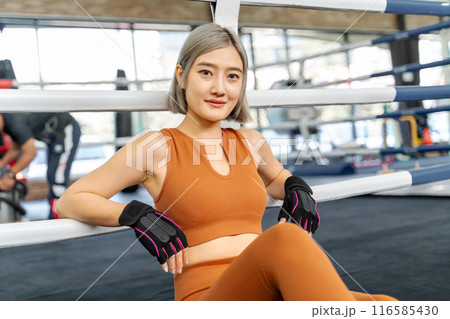 Portrait of a beautiful woman in brown fitness clothes resting at a local gym 116585430