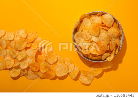 Potato chips in a bowl on a yellow background Potato chips in a bowl on a yellow background 116585443
