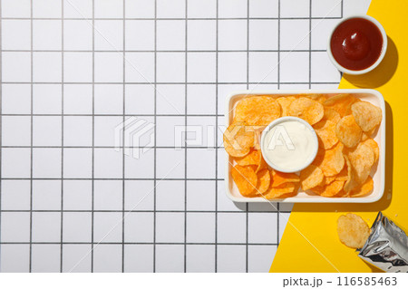 Potato chips in a bowl with sauces on a light background 116585463