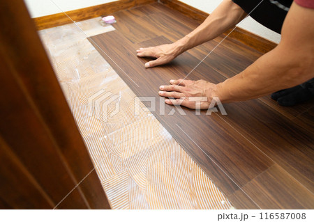 中古住宅のリフォームで廊下の床にフロアタイルを貼るクロス職人 中古住宅のリフォームで廊下の床にフロアタイルを貼るクロス職人 116587008